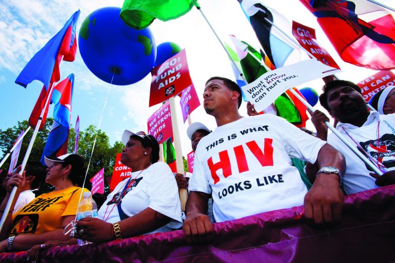 Marco Benjamin, 32, of New Brunswick, New Jersey, second from right, who is HIV positive, walks in the AIDS March in Washington, Sunday, July 22, 2012.