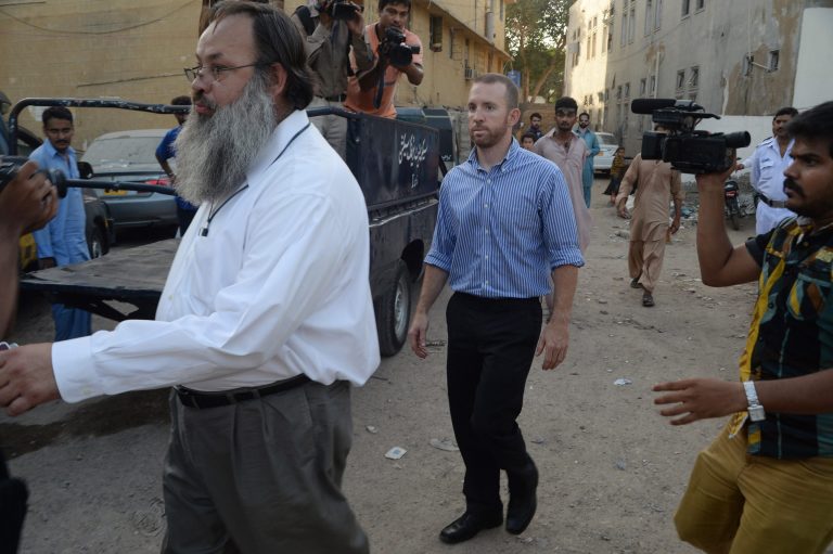 An American national, center, reportedly working for the FBI, leaves a police station in Karachi, Pakistan, Thursday, May 8, 2014. Pakistan released an FBI agent on bail Thursday after three days in custody, officials said, a move that is likely to prevent the situation from escalating into a diplomatic spat. The American man was detained after airport authorities found him carrying ammunition and three knives Monday as he was about to board a flight for the Pakistani capital, Islamabad.(AP Photo/Mohammad Khalil)