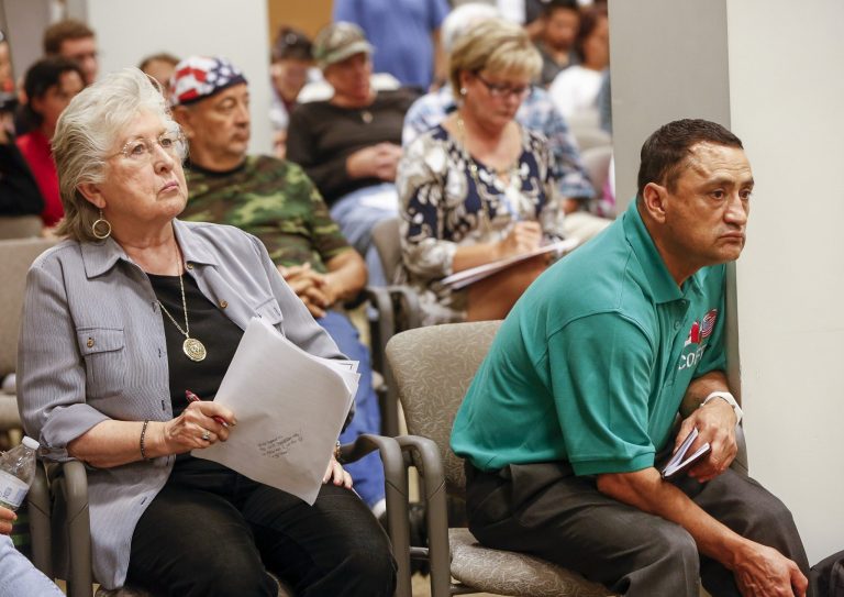 Carol Schlepper, left, and Jose Felix Cabrera join about 100 people attending a California Department of Motor Vehicles hearing downtown Los Angeles on Tuesday, June 24, 2014 to take public comments on proposed rules by which immigrants in the country illegally may obtain driver's licenses. The state expects 1.4 million people to apply in the first three years. (AP Photo/Damian Dovarganes)
