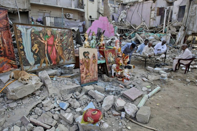   Members of Pakistani Hindu community sit next to the rubble of a Hindu temple, which was destroyed on Saturday by a builder, in Karachi, Pakistan, Sunday, Dec. 2, 2012. Members of the Pakistan Hindu community in the southern port city of Karachi protested on Sunday over the destruction of a Hindu temple Saturday by a builder who claimed that the land is his. (AP Photo/Fareed Khan)  