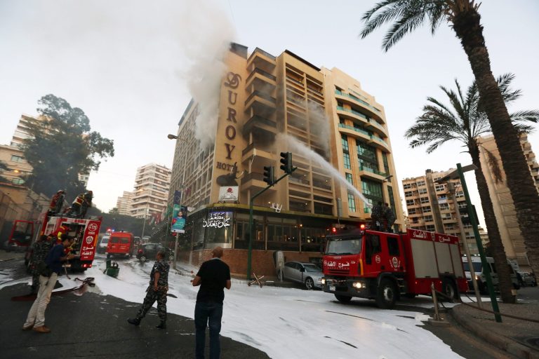 Fire engines work on extinguishing a fire after a suicide bomber blew himself up in his room at a Beirut hotel, Lebanon, Wednesday, June 25, 2014, as Lebanese security forces raided the premises. The bombing is the latest in a string of attacks and security sweeps in Lebanon over the past week that have sparked fears of renewed violence in a country that has been deeply affected by the civil war in neighboring Syria. (AP Photo/Bilal Hussein)