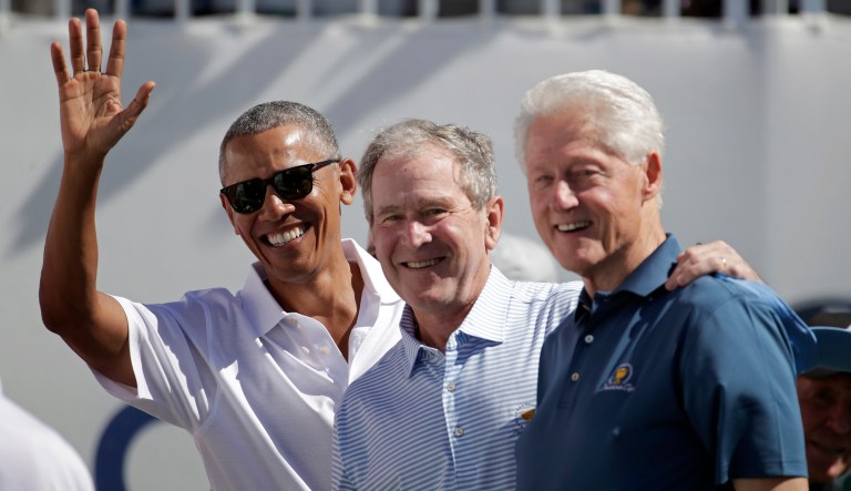 Former Presidents Barack Obama, George W. Bush, and Bill Clinton greet spectators on the first tee before the first round of the Presidents Cup at Liberty National Golf Club in Jersey City, N.J. (AP Photo/Julio Cortez)