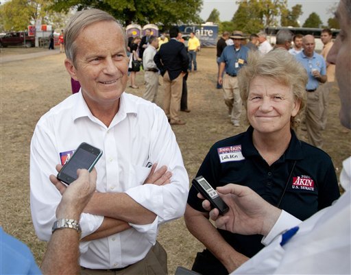 In this Thursday, Aug. 16, 2012 photograph, Rep. Todd Akin, R-Mo., and his wife Lulli, talk with reporters while attending the Governor's Ham Breakfast at the Missouri State Fair in Sedalia, Mo. Akin was keeping a low profile, Monday, Aug. 20, 2012, a day after a TV interview in which he said that women's bodies can prevent pregnancies in 