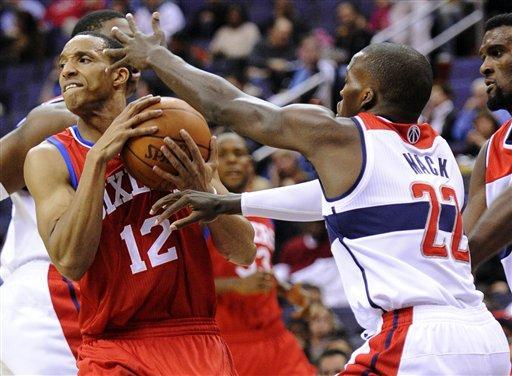 Philadelphia 76ers guard Evan Turner (12) tries to get past Washington Wizards guard Shelvin Mack (22) during the first half of an NBA preseason basketball game, Friday, Dec. 16, 2011, in Washington.