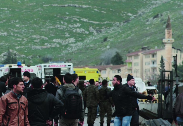 People and ambulances seen near the Cilvegozu customs gate at Turkey-Syria border near Reyhanli, Hatay, Turkey, Monday, Feb. 11, 2013 minutes after a car bomb exploded. Turkey's deputy prime minister Bulent Arinc said 12 people died and 28 were wounded and taken to hospitals in Turkey. (AP Photo/Gaia Anderson)