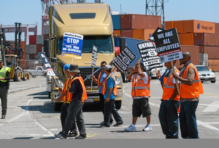 Members of the Teamsters Union picket at LBCT in the Port of Long Beach, Calif., in support of a strike by port truck drivers Tuesday, July 8, 2014. Nearly 1,000 dockworkers briefly walked off their jobs Tuesday at the massive ports of Los Angeles and Long Beach, disrupting the movement of international cargo before a mediator ordered them back. (AP Photo/The Daily Breeze, Stephen Carr)