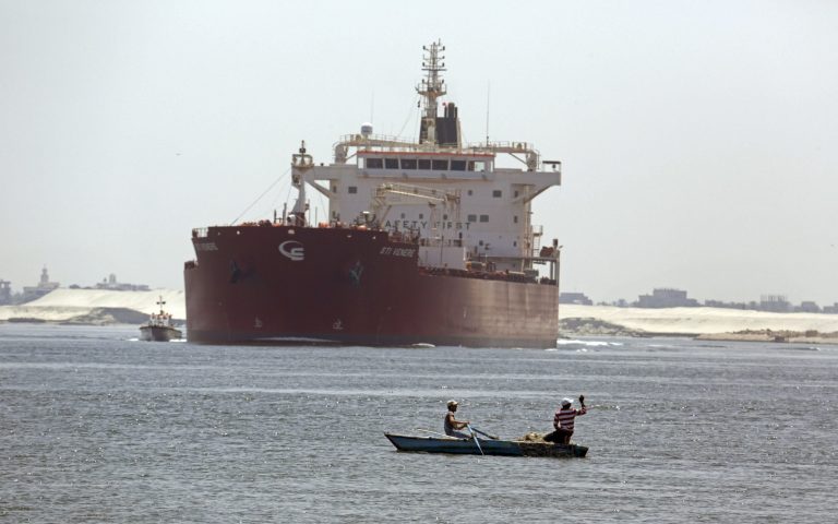 FILE - In this Tuesday, Aug. 12, 2014 file photo, Egyptian fishermen fish in front of a Maltese ship crossing the Suez Canal in Ismailia, Egypt. Egypt selected a consortium of Egyptian and the Persian Gulf companies to develop the government's mega project to transform the Suez Canal waterway into a hub of international investment and free trade zones, officials said on Tuesday, Aug. 19, 2014.(AP Photo/Amr Nabil, File)