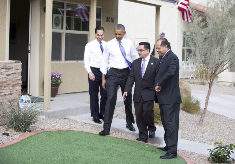 President Barack Obama, joined by Housing and Urban Development Secretary Julian Castro, left, and Chicanos Por La Causa's Edmundo Hidalgo, right, and David Adame, steps onto a putting green outside a home in a housing development, Thursday, Jan. 8, 2015, in Phoenix. (AP Photo/Carolyn Kaster)