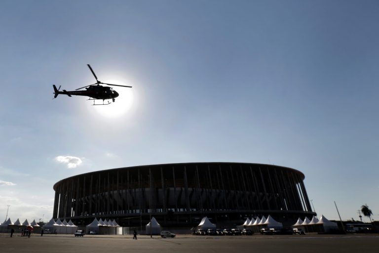 Police helicopter hovers in front of the National Stadium during a practice for security operations for the 2014 FIFA World Cup, in Brasilia, Brazil, Thursday, May 22, 2014. The football stadium is a multi-purpose arena that will host games during the 2014 FIFA World Cup soccer tournament that starts in June. (AP Photo/Eraldo Peres)
