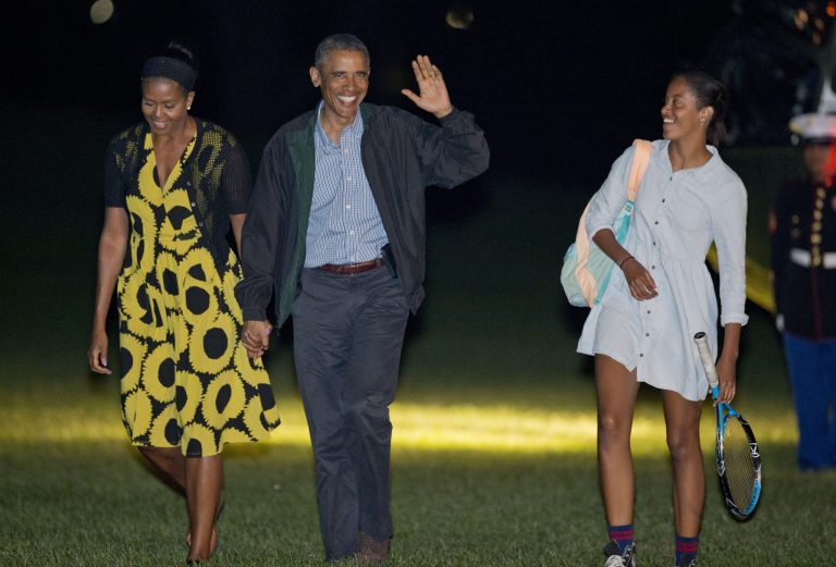 President Barack Obama, center, and first lady Michelle Obama, left, walk with their daughter Malia, right, across the South Lawn of the White House in Washington, Sunday, Aug. 24, 2014, following their arrival on Marine One helicopter. Obama returned to Washington after spending two weeks with his family on the island of Martha's Vineyard. (AP Photo/Pablo Martinez Monsivais)