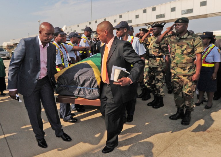 The remains of journalist Nat Nakasa, in a coffin draped in a South African flag, arrives in Durban, South Africa, Tuesday, Aug. 19, 2014 where he will be reburied, South Africa's arts and culture ministry said. South Africa is repatriating the remains of Nakasa, a black anti-apartheid journalist, who died in the United States in 1965 and was buried there until his recent exhumation. (AP Photo)
