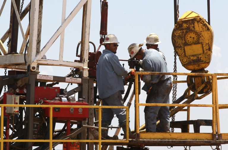 Workers are pictured on a drilling rig near Calumet, Okla., in July 2012. Oklahoma is one of several states that have enjoyed a boom in the energy sector driven in large part by new and improved drilling techniques such as horizontal drilling and hydraulic fracturing, which cracks open fissures in rock formations to retrieve oil and gas. (AP Photo/Sue Ogrocki)
