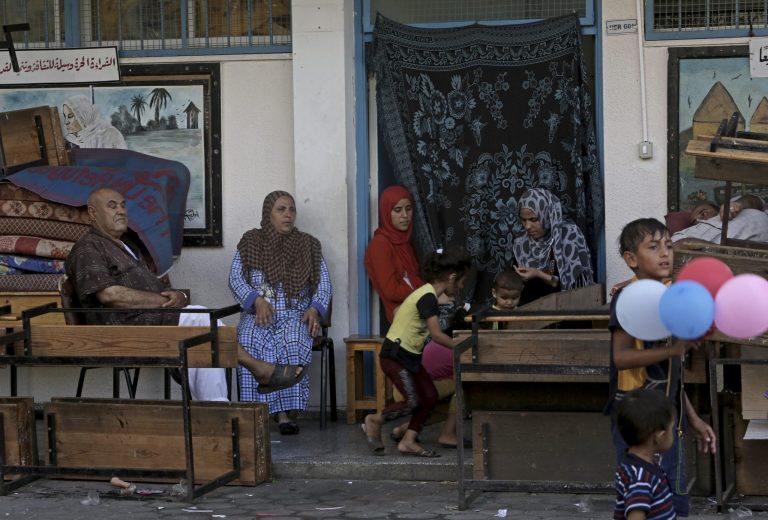 Displaced Palestinian family members pass their time at the U.N. school where they sought refuge during the war, in Beit Lahiya, in the northern Gaza Strip, Tuesday, Aug. 12, 2014. Tens of thousands of Palestinians have been displaced in the Israel-Hamas war that began July 8, at least 10,000 housing units have been destroyed and many have found refuge at U.N. schools turned into shelters. (AP Photo/Adel Hana)