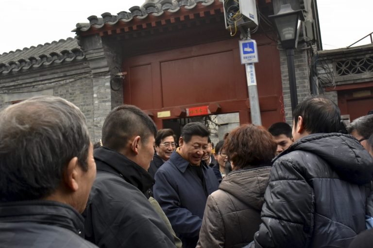 FILE - In this Tuesday Feb. 25, 2014 file photo, Chinese President Xi Jinping, center, is surrounded by onlookers and television crew during an unannounced visit to a residential alley in Beijing. Xi looks more powerful than any Chinese leader in recent decades as his government prepares to deliver its first one-year report card Wednesday, March 5 but a deadly weekend slashing spree by alleged separatists was a reminder of the serious challenges facing his administration. In recent weeks, Xi has put himself in charge of a new top-level party committee focused on steering state security, a panel on driving sweeping economic reforms, and another on cybersecurity. (AP Photo/File) CHINA OUT