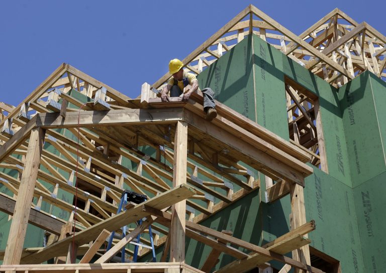 In this Wednesday, July 30, 2014 photograph, a builder works on the construction of new homes in Belmar, N.J. U.S. home construction rebounded in July, rising to the fastest pace in eight months and offering hope that housing has regained momentum after two months of declines. (AP Photo/Mel Evans)