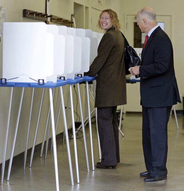 California Gov. Jerry Brown, right, speaks to a voter as he leaves a polling area Tuesday, June 3, 2014, in Oakland, Calif. (AP Photo/Ben Margot)