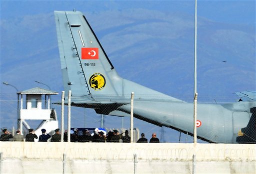 Turkish army officers salute as Turkish honor guard carry the coffin of Russian pilot Lt. Col. Oleg Peshkov, whose plane was shot down by Turkish jets last Tuesday when the Russian plane crossed into Turkish airspace. (DHA via AP )