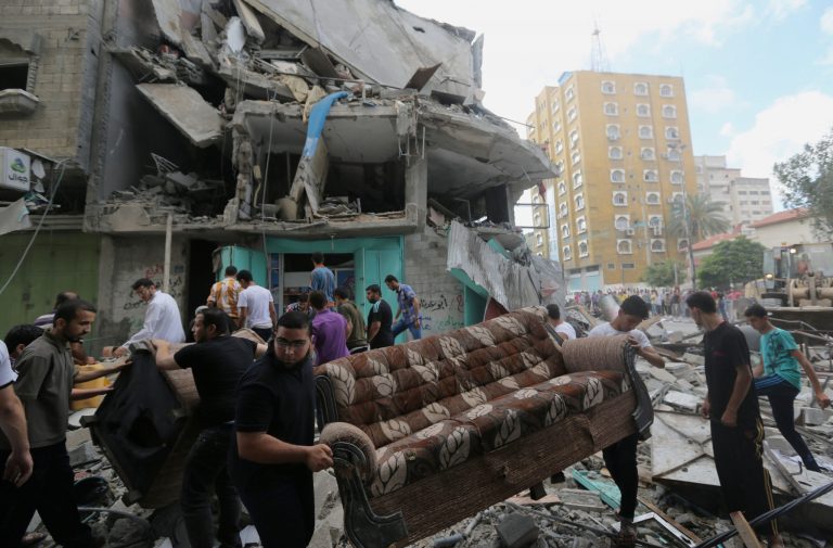 Palestinians salvage their usable belongings from the rubble of their homes in an apartment building after it was hit by an Israeli missile strike in Gaza City, Friday, July 18, 2014. Israeli troops pushed deeper into Gaza on Friday to destroy rocket launching sites and tunnels, firing volleys of tank shells and clashing with Palestinian fighters in a high-stakes ground offensive meant to weaken the enclave's Hamas rulers. (AP Photo/Hatem Moussa)