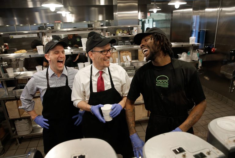 U.S. Labor Secretary Thomas Perez (C) talks with Shake Shack employee Jamelle Bland (R) while making a milkshake during a tour of the restaurant with Shake Shack CEO Randy Garutti (L) March 21, 2014 in Washington, DC. (Photo by Win McNamee/Getty Images)