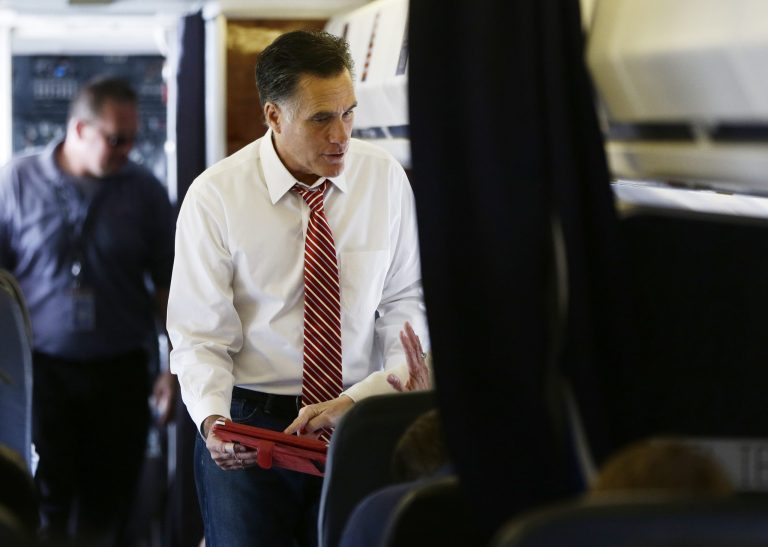 Massachusetts Gov. Mitt Romney looks over an iPad as he speaks to advisers on his campaign plane in Denver. (AP Photo)