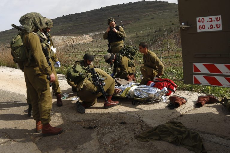 A wounded Israeli soldier is treated in the Golan Heights, Tuesday, March 18, 2014. A roadside bomb hit an Israeli patrol near the frontier with the Golan Heights on Tuesday, the army said, wounding four soldiers in the most serious violence to strike the area since the Syrian conflict began three years ago. Israel said it responded with artillery strikes on Syrian army targets. Israel captured the Golan Heights from Syria in the 1967 Middle East war and later annexed the strategic area in a move that was not internationally recognized. (AP Photo/Jinipix) ****ISRAEL OUT***