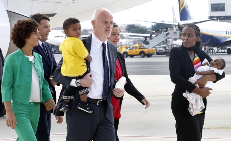 Meriam Ibrahim, from Sudan, right, holds her baby girl Maya, accompanied by Italian deputy Foreign Miinister Lapo Pistelli, holding her son Martin, followed by Italian Foreign Minister Federica Mogherini, second from right, Italian Premier Matteo Renzi, second from left, and his wife Agnese Landini, after landing from Khartoum, at Ciampino's military airport, on the outskirts of Rome, Thursday, July 24, 2014. The Sudanese woman who was sentenced to death in Sudan for refusing to recant her Christian faith has arrived in Italy along with her family, including an infant born in prison. An Italian diplomat who accompanied the family from Sudan said Italy leveraged its historic ties within the Horn of Africa region to help win her release.  (AP Photo/Riccardo De Luca)