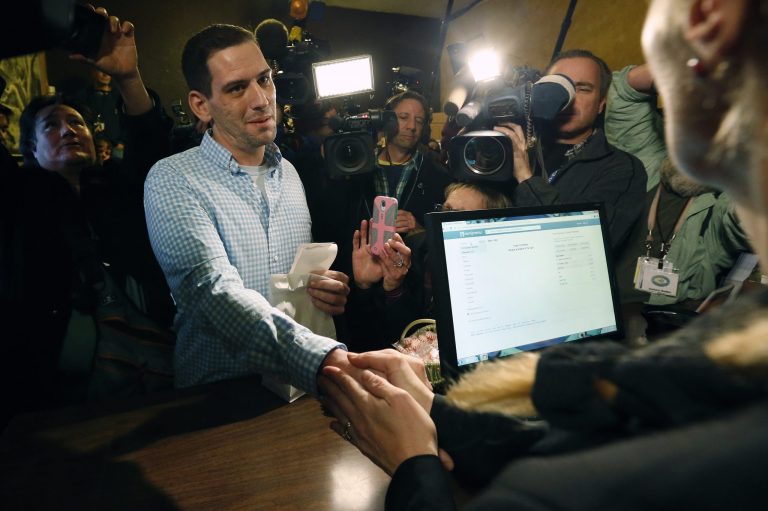 Sean Azzariti, a former Marine who served in the Iraq war and has post-traumatic stress disorder, shakes hands and thanks store owner Toni Fox, after Azzariti was the first to buy retail marijuana at 3D Cannabis Center, which opened as a legal recreational retail outlet in Denver on Jan. 1. (AP/Brennan Linsley)