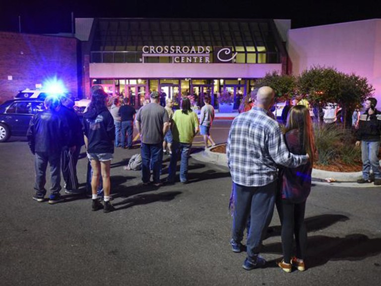 People stand near an entrance to the Crossroads Center mall as officials investigate a multiple stabbing incident, Saturday, Sept. 17, 2016, in St. Cloud, Minn.(Dave Schwarz/St. Cloud Times via AP)