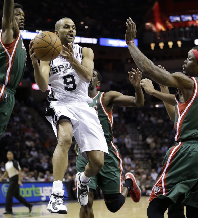   San Antonio Spurs' Tony Parker (9), of France, drives between Milwaukee Bucks' Larry Sanders,left, and Marquis Daniels, right, during the first quarter of an NBA basketball game on Wednesday, Dec. 5, 2012, in San Antonio. San Antonio won 99-95. (AP Photo/Eric Gay)  