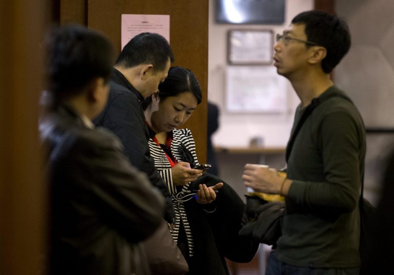Chinese relatives of passengers aboard a missing Malaysia Airlines plane stand inside a hotel room after attending a briefing by Malaysia Airlines in Beijing, China Sunday, March 16, 2014. Attention focused Sunday on the pilots of the missing Malaysia Airlines flight after the country's leader announced findings so far that suggest someone with intimate knowledge of the Boeing 777's cockpit seized control of the plane and sent it off-course. (AP Photo/Andy Wong)