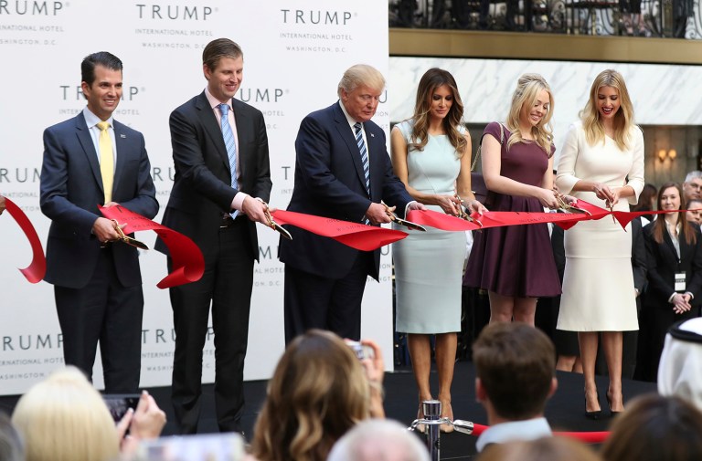 Republican presidential candidate Donald Trump, together with his family, from left, Donald Trump Jr., Eric Trump, Trump, Melania Trump, Tiffany Trump and Ivanka Trump, cut the ribbon during the grand opening of Trump International Hotel in Washington, Wednesday, Oct. 26, 2016. (AP Photo/Manuel Balce Ceneta)