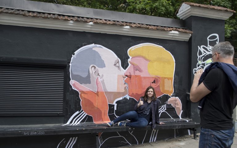 The smooch alludes to what some fear are Trump's overly indulgent views toward Russia's authoritarian president. (AP Photo/Mindaugas Kulbis)
