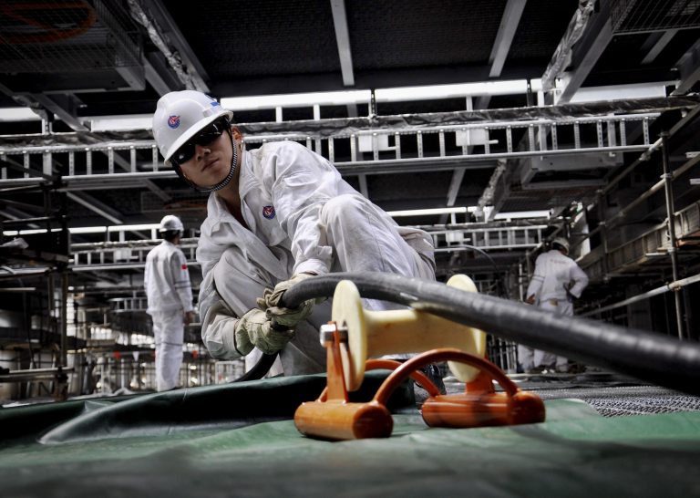 In this Sept. 11, 2014 photo, workers lay cables on a new oil rig under construction for China National Offshore Oil Corp. (CNOOC) in a shipyard in Qingdao in east China's Shandong province.  The Chinese exploration rig at the center of a tense maritime standoff with Vietnam earlier this year has made its first deep sea gas discovery in the politically volatile South China Sea, state media announced Tuesday, Sept. 16. The discovery by CNOOC was made about a month after its rig withdrew in July from Vietnam's exclusive economic zone to far less-contested waters closer to China. (AP Photo) CHINA OUT