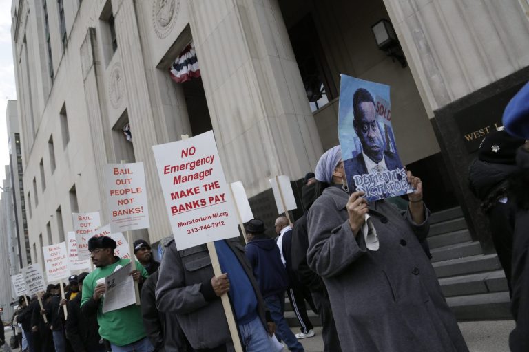 Protestors, against deeper cuts in pensions, march in front of the Theodore Levin Federal Courthouse in Detroit, Tuesday Apr. 1, 2014. Detroit's updated bankruptcy plan was filed in federal court on Monday, revealing new details on how the city plans to restructure its debt and provide public services during the largest municipal bankruptcy in U.S. history. (AP Photo/Detroit Free Press, Mandi Wright)  DETROIT NEWS OUT;  NO SALES