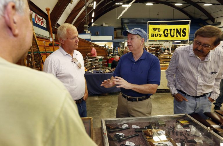 Former presidential candidate Sen. Lindsey Graham, R-S.C., second from right, talks with gun dealers during a campaign stop at the Gun Show in Concord, N.H. last year. (AP Photo/Jim Cole)