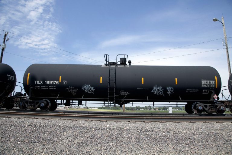 In this Aug. 8, 2012 photo, a DOT-111 rail tanker passes through Council Bluffs, Iowa. Federal regulators proposed new rules Tuesday designed to prevent unattended railcars carrying crude oil from running off the tracks. (AP Photo/Nati Harnik, File)