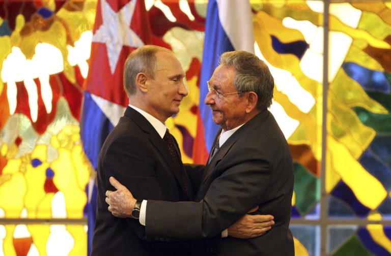 Russia's President Vladimir Putin, left, and Cuba's President Raul Castro embrace at Revolution Palace in Havana, Cuba, Friday, July 11, 2014. Putin began a six-day Latin American tour aimed at boosting trade and ties in the region with a stop Friday in Cuba, a key Soviet ally during the Cold War that has backed Moscow in its dispute with the West over Ukraine. (AP Photo/Alejandro Ernesto, Pool)