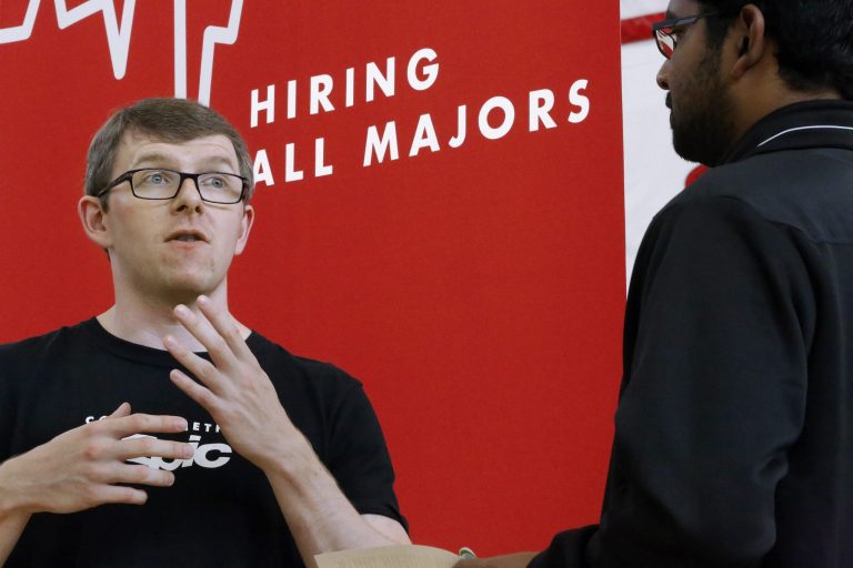 In this Sept. 25, 2014 photo, Jacob Robinson, left, of Epic, an electronic health record software company, speaks with students attending The Foot in the Door Career Fair at the University of Illinois Springfield in Springfield, Ill. The Labor Department releases weekly jobless claims on Thursday, Oct. 2, 2014. (AP Photo/Seth Perlman)