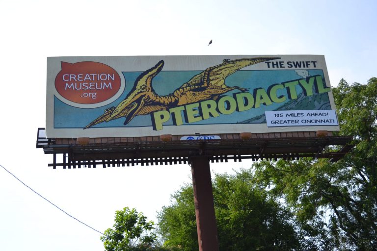   A billboard in Louisville, Ky., shows a new ad campaign for the Creation Museum, on June 11, 2012. A new nationwide billboard ad campaign is using dinosaurs to attract visitors to the Bible-based center near Cincinnati. The museum has exhibits that challenge evolution science and promote a literal interpretation of the Old Testament's creation story. (AP Photo/Dylan Lovan)  