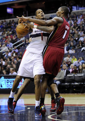 Washington Wizards forward Trevor Ariza (1, white jersey) drives to the basket against Miami Heat center Chris Bosh (1, red jersey) during the Wizards' 105-101 victory Tuesday night. (AP Photo/Nick Wass)