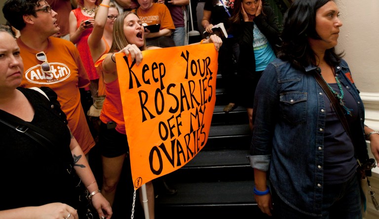 FILE - In this July 13, 2013 file photo, abortion rights advocates, left, protest in the State Capitol as anti-abortion rights supporters pass them in Austin, Texas.