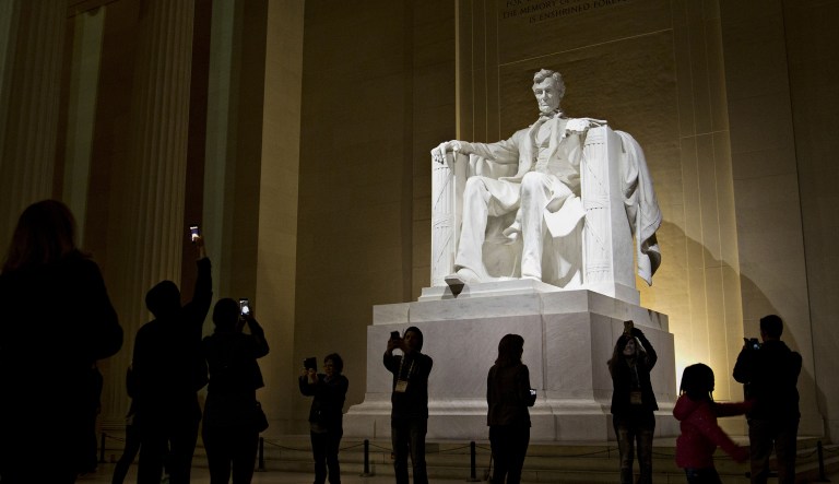 Visitors view the statue of former President Abraham Lincoln at the Lincoln Memorial at night in Washington, D.C., U.S., on Tuesday, Feb. 27, 2018.