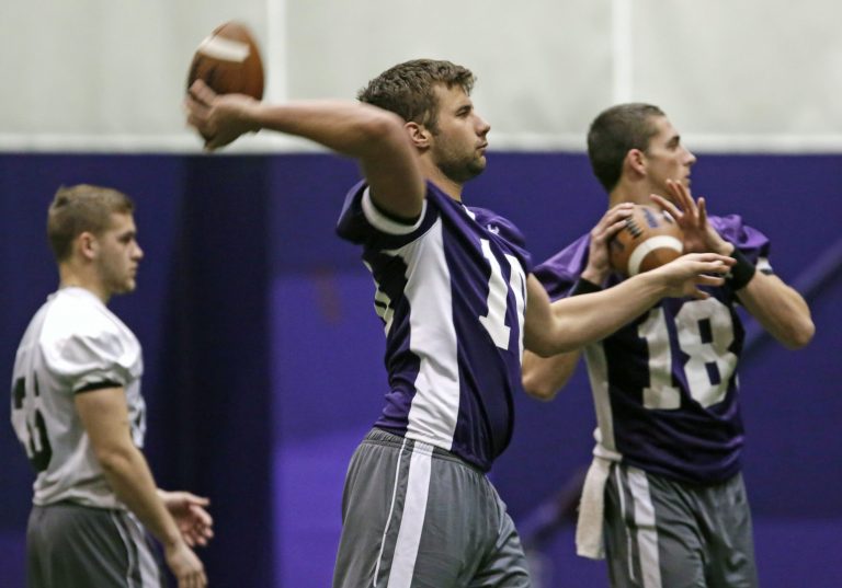 Northwestern quarterbacks Zack Oliver, center, and Christian Salem, right, throw as the football team participates in an NCAA college spring football practice Tuesday, April 1, 2014, in Evanston, Ill. After spring break, Northwestern resumed spring football practices with a huge issue that could change the college sports landscape hanging over their heads. A regional director of the National Labor Relations Board ruled last week that the team can bargain with the school as employees. (AP Photo/M. Spencer Green)
