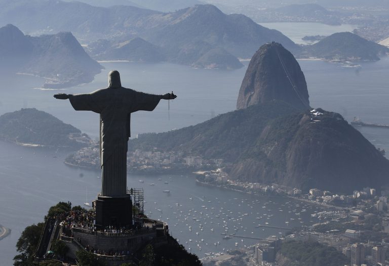 FILE - In this June 27, 2014 file photo, Christ the Redeemer statue is silhouetted next to Sugar Loaf Mountain, in Rio de Janeiro, Brazil. Rio's Archbishop Orani Tempesta presided over a ceremony Friday, July 11, 2014, marking the end to repairs made to the city's famed statue. The $856,000 repair project began six months ago after two fingers and part of the statue's head were chipped during lightning storms. (AP Photo/Leo Correa, File)