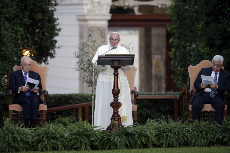 Pope Francis delivers his message as he is flanked by Israel's President Shimon Peres, left, and Palestinian President Mahmoud Abbas during an evening of peace prayers in the Vatican gardens, Sunday, June 8, 2014. Pope Francis waded head-first into Mideast peace-making Sunday, welcoming the Israeli and Palestinian presidents to the Vatican for an evening of peace prayers just weeks after the last round of U.S.-sponsored negotiations collapsed. (AP Photo/Gregorio Borgia)