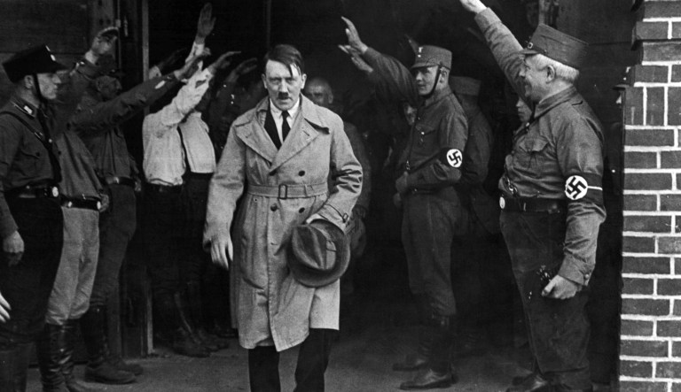 In this Dec. 5, 1931 file photo, Adolf Hitler, leader of the National Socialists, is saluted as he leaves the party's Munich headquarters. In Munich, Hitler launched his political career with speeches condemning Jews and proclaiming the ethnic superiority of Germans.