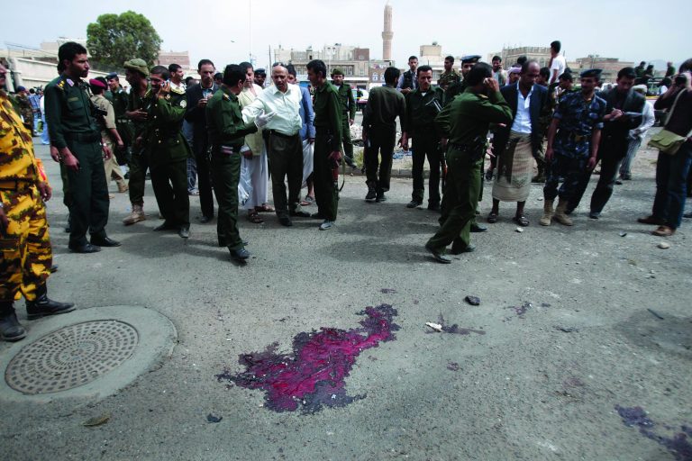 Forensic policemen collect evidence at the site of a suicide bomb attack at a police academy in Sanaa, Yemen, Wednesday, July 11, 2012. A suicide bomber threw himself into a crowd of Yemeni police cadets leaving their academy on Wednesday and detonated his explosives, killing several people, a security official said.(AP Photo/Hani Mohammed)