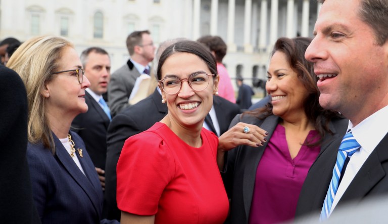 Representative-elect Alexandria Ocasio-Cortez, a Democrat from New York, smiles after a group photo with the 116th Congress outside the U.S Capitol in Washington, D.C., U.S., on Wednesday, Nov. 14, 2018. Congress returns to work this week with Democrats and Republicans promising to work together to avert a partial government shutdown and pass a handful of other bills, though President Donald Trump's demand to fund his border wall could blow up their plans.
