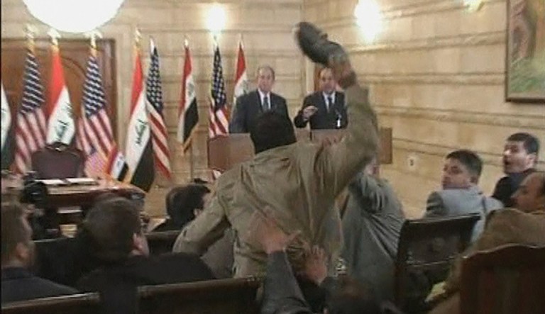 In this image from APTN video, a man, centre throws a shoe at US President George W. Bush, background left, during a news conference with Iraq Prime Minister Nouri al-Maliki, Sunday, Dec. 14, 2008, in Baghdad, Iraq. On an Iraq trip shrouded in secrecy and marred by dissent, President George W. Bush on Sunday hailed progress in the war that defines his presidency and got a size-10 reminder of his unpopularity when a man hurled two shoes at him during a news conference.