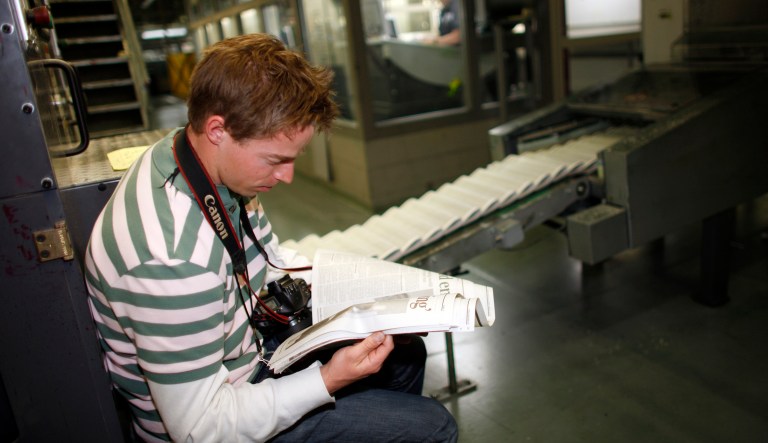 Photo intern Brian Lehman looks over the final edition of the Rocky Mountain News as it comes off the presses in the Washington Street Printing Plant of the Denver Newspaper Agency in Denver on Thursday, Feb. 26, 2009. E.W. Scripps Co., owners of the News, which is Colorado's oldest newspaper dating back to 1859, announced on Thursday that the paper will cease publication with the Friday, Feb. 27 edition. 